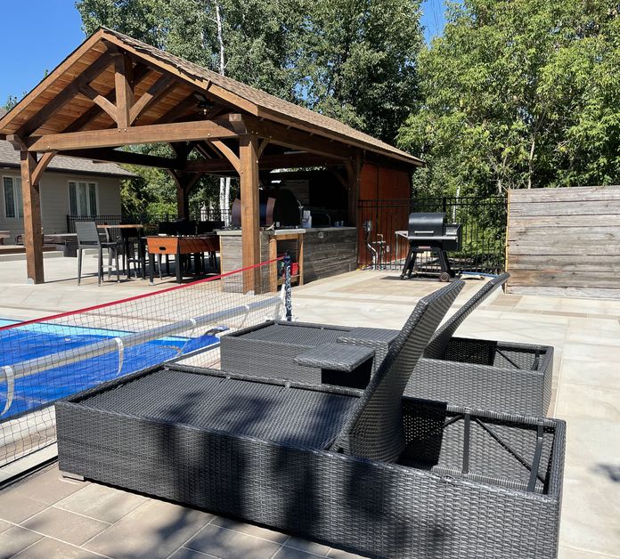 Backyard pool with lounge chairs and covered eating area